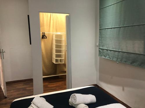 バレンシアにあるMar & City Apartmentの鏡付きの部屋、タオル付きのベッド