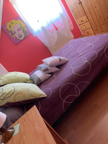 - une chambre avec un lit doté de draps et d'oreillers violets dans l'établissement maison privée offre chambre hôte, à Kingersheim