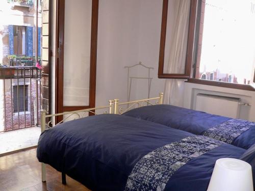 a bedroom with a bed with a blue comforter at Cà Dolce in Venice