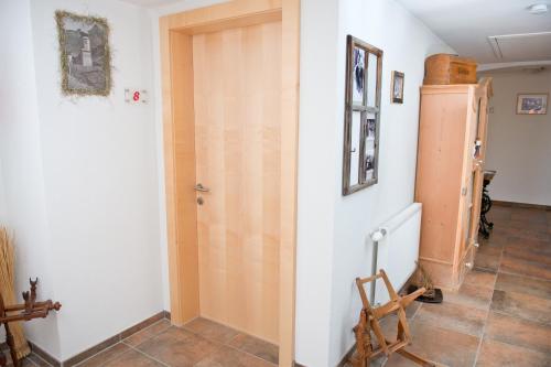 a room with a wooden door and a tiled floor at Hotel Garni Ragaz in Damuls