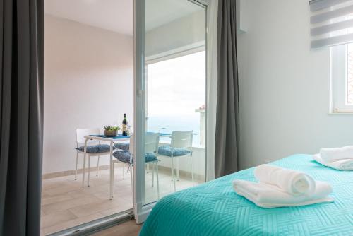 um quarto com uma cama e uma mesa com vista para o oceano em TopHill Deluxe em Dubrovnik