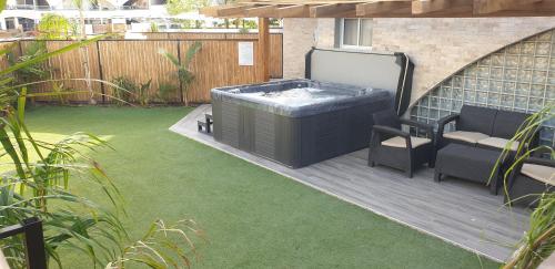 a patio with a hot tub and a chair on a lawn at Avshalom Holiday Apartments in Eilat
