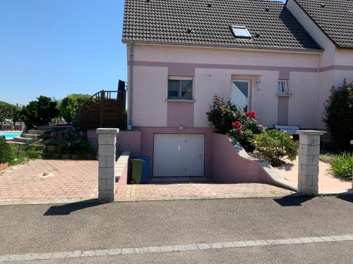 ein rosa Haus mit Garage davor in der Unterkunft Maison privée in Kingersheim