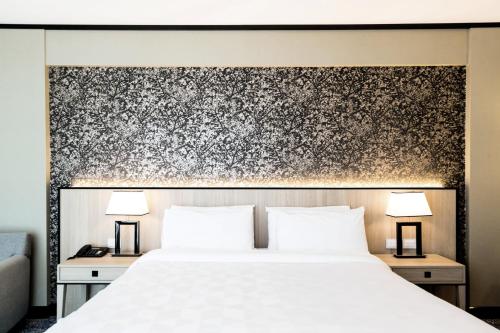 a bedroom with a white bed and two lamps at Holiday Inn Rosario by IHG in Rosario