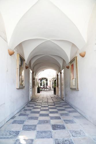 an arcade of a building with white ceilings and a tile floor at Stylische Cityapartments Benedikt in Klagenfurt