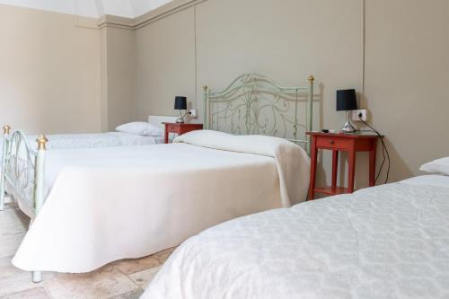 1 Schlafzimmer mit 2 Betten und 2 Tischen mit Lampen in der Unterkunft B&B Santi Medici in Bitonto