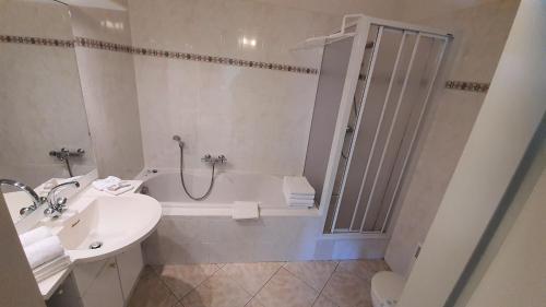 a bathroom with a tub and a sink and a toilet at Residence Chateau de Barbet in Lombez