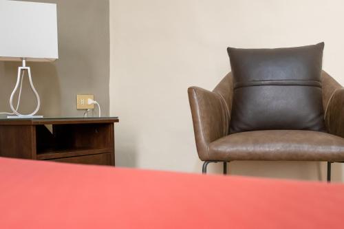 a brown chair sitting next to a table with a lamp at B&B Santi Medici in Bitonto