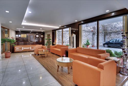 a living room with orange couches and a table at Ekant Retreat Resort in Chail