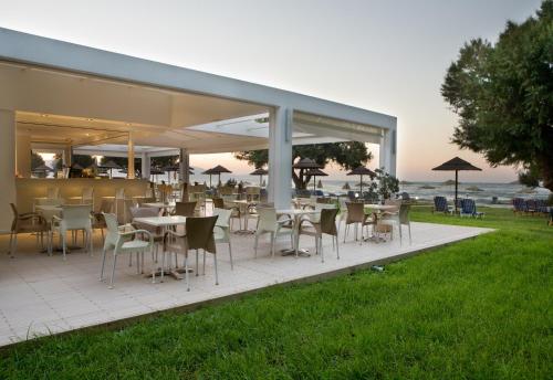 a restaurant with tables and chairs on a patio at Geraniotis Hotel and Resort in Plataniás