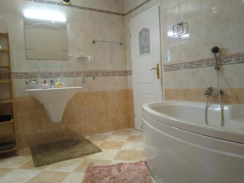 y baño con bañera blanca y lavamanos. en Apartament nad zalewem przy plaży, en Jedlnia-Letnisko