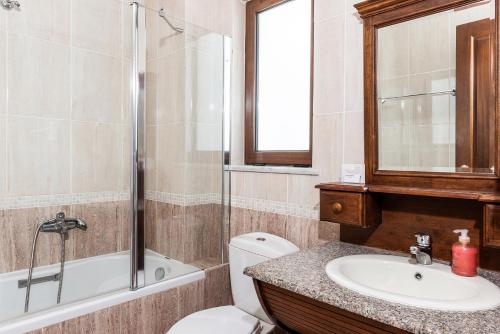 a bathroom with a toilet and a sink and a shower at Geraniotis Hotel and Resort in Plataniás