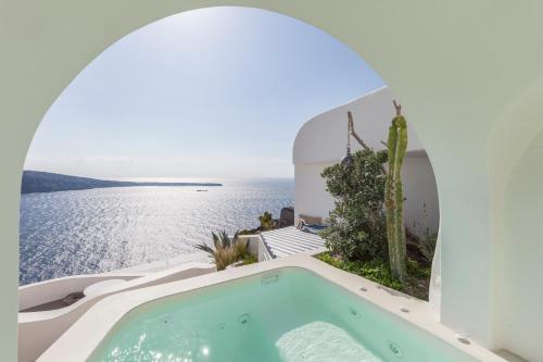 a pool in a house with a view of the ocean at Spitia Santorini Villa Collection in Oia