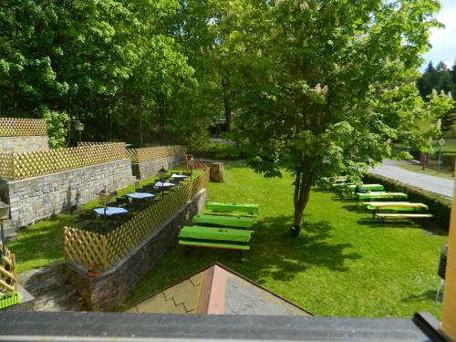 une rangée de tables et de chaises dans un parc avec un arbre dans l'établissement Pension Sommerfrische, à Ehrenfriedersdorf