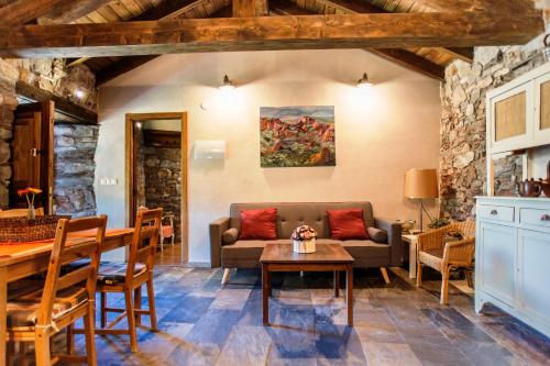 a living room with a couch and a table at Rural Médulas Viviendas de uso turistico 2 y Casas rurales 2 in Las Médulas
