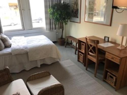 a bedroom with a bed and a table and a desk at Tapulitalo Guesthouse in Turku