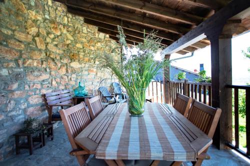 a wooden table with a vase of flowers on a patio at Rural Médulas Viviendas de uso turistico 2 y Casas rurales 2 in Las Médulas