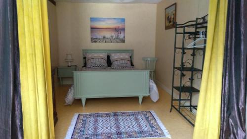 a bedroom with a bed with yellow curtains at maison de campagne in Cour-Cheverny