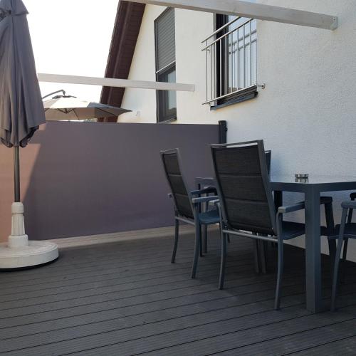 a table and chairs on a balcony with an umbrella at Susi"s Ferienwohnungen in Wermelskirchen