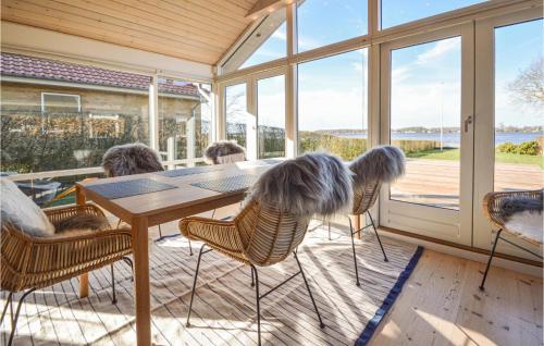 a screened in porch with a table and chairs at 3 Bedroom Cozy Home In Sunds in Sunds