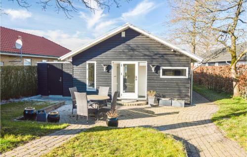 a small house with a table and chairs in a yard at 3 Bedroom Cozy Home In Sunds in Sunds