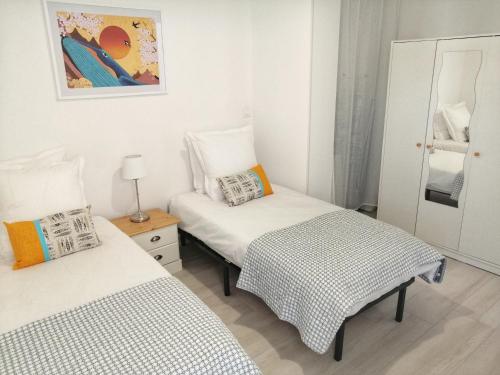Duas camas num pequeno quarto com paredes brancas em Le Piade, confort moderne, vue dégagée, clim, ascenseur, WiFi em Sète