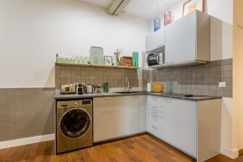 uma cozinha com uma máquina de lavar roupa e uma máquina de lavar roupa em Edgar Suites Louvre - Saint-Honoré em Paris