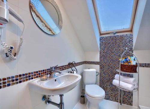 a bathroom with a sink and a toilet and a mirror at Apartament Bieszczadzkie Klimaty in Ustrzyki Dolne
