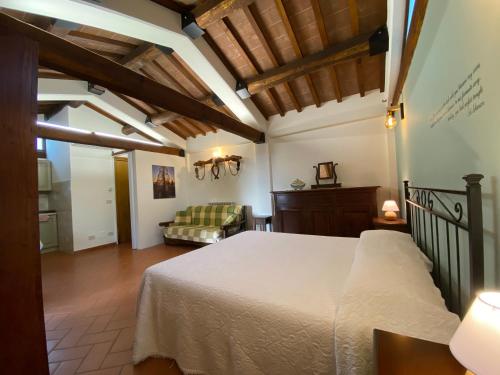 a bedroom with a bed and a couch in a room at Agriturismo Tenuta Badia in Paciano