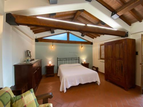 a bedroom with a white bed and a window at Agriturismo Tenuta Badia in Paciano