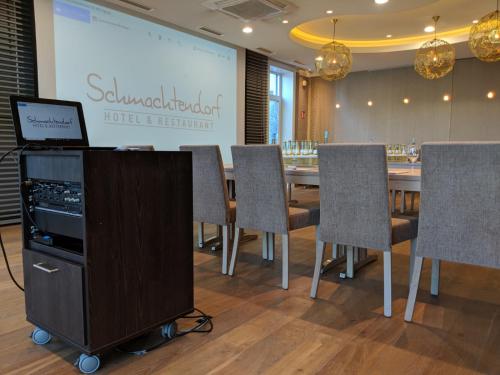 a conference room with a table and chairs and a screen at Hotel Schmachtendorf in Oberhausen