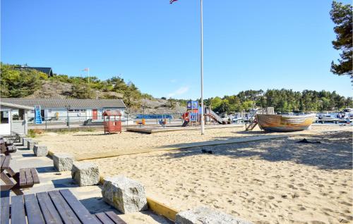 una spiaggia con panchina e barca di Beautiful Home In Søgne With Wifi a Søgne