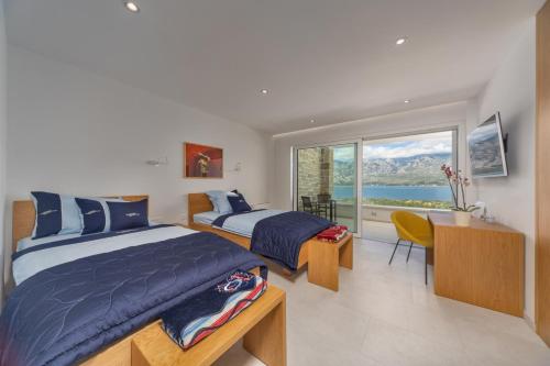 two beds in a bedroom with a view of the ocean at Sea Star Villa - Vinjerac in Vinjerac