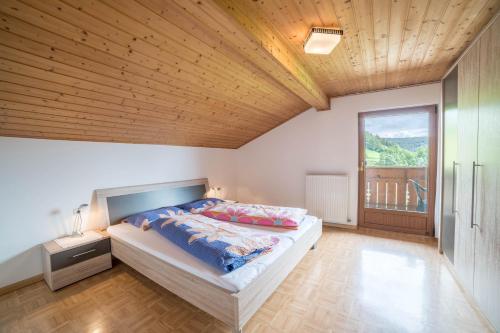 a bedroom with a bed and a large window at Greif - Apartment C in Verano