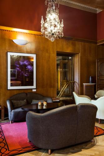 a living room with a couch and a chandelier at Elite Plaza Hotel in Gothenburg