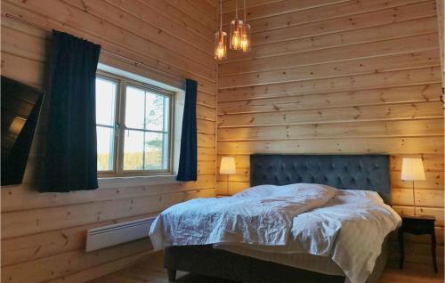 ein Schlafzimmer mit einem Bett in einer Holzwand in der Unterkunft Beautiful Home In Vemdalen With House A Mountain View in Vemdalen