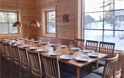 a long wooden table in a room with windows at Stunning Home In Vemdalen With Sauna in Vemdalen