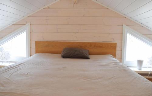 uma cama num quarto com duas janelas em Lovely Home In Frjestaden With Kitchen em Färjestaden
