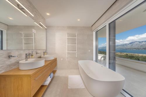 La salle de bains est pourvue de 2 lavabos et d'une grande fenêtre. dans l'établissement Sea Star Villa - Vinjerac, à Vinjerac