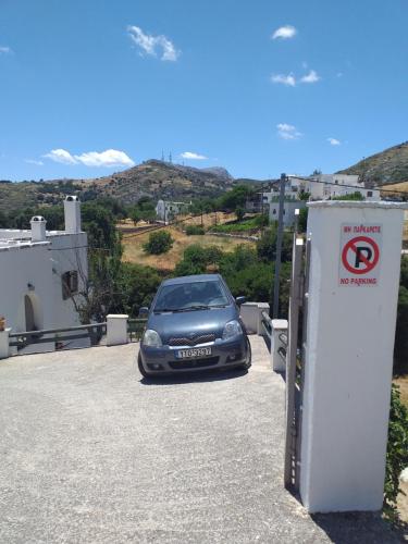 a car is parked next to a no parking sign at Imellos in Apeiranthos