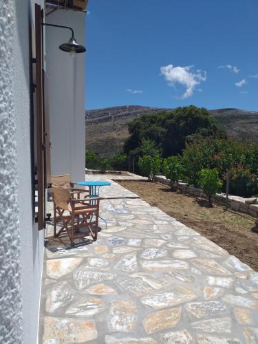 a patio with a table and chairs on the side of a building at Imellos in Apeiranthos