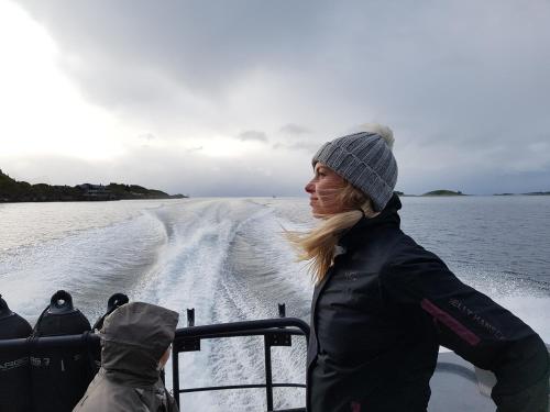 a woman standing on a boat in the water at Mefjord Brygge in Mefjordvær