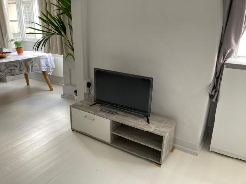 a flat screen tv sitting on a stand in a living room at Golden Cross Guesthouse in Oxford