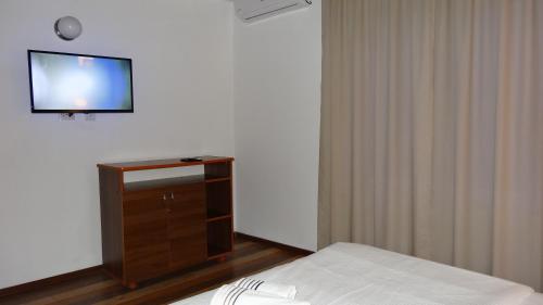 a room with two beds and a tv on a wall at Vila Calypso Costinesti in Costinesti