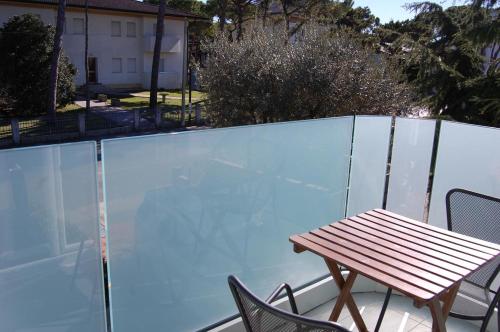 einen Holztisch und Stühle auf dem Balkon in der Unterkunft Hotel Irene in Lignano Sabbiadoro