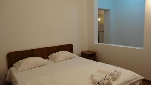 a bedroom with a bed with two pillows and a mirror at Vila Calypso Costinesti in Costinesti