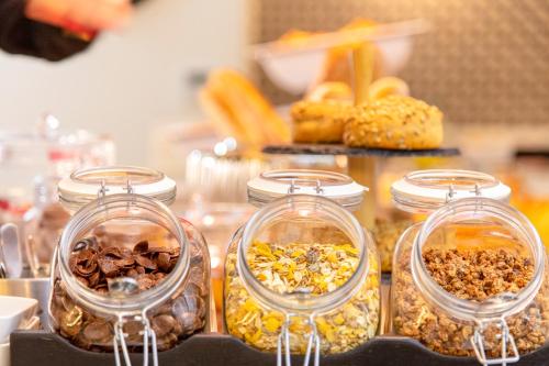 four glass jars filled with different types of food at Novotel Constantine in Constantine