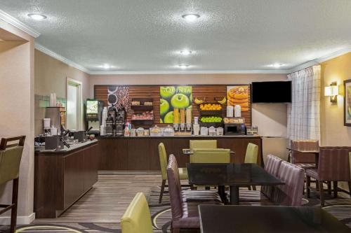 a restaurant with a bar and a table and chairs at La Quinta by Wyndham N Little Rock - McCain Mall in Little Rock