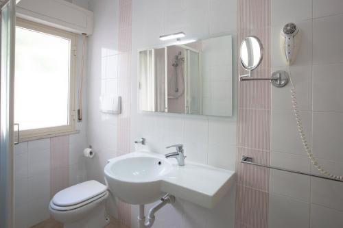 a bathroom with a sink and a toilet and a mirror at Appartamenti Tallinucci in Lacona