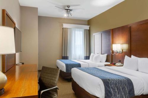 a hotel room with two beds and a chair at Comfort Inn & Suites Amarillo East in Amarillo